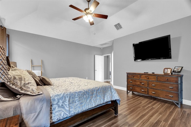 bedroom featuring a tray ceiling, ceiling fan, and dark wood-type flooring