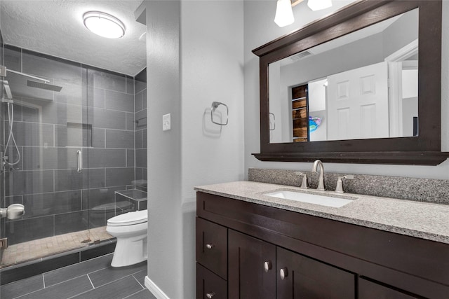 bathroom with an enclosed shower, vanity, toilet, and a textured ceiling