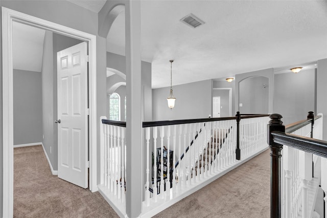 corridor with light colored carpet and vaulted ceiling