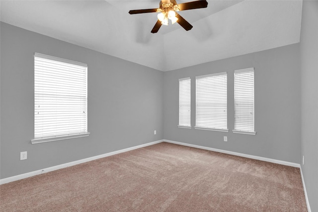 carpeted spare room with ceiling fan and vaulted ceiling