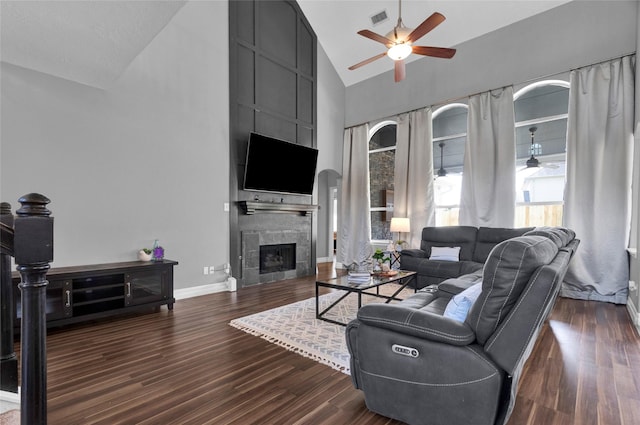 living room featuring a fireplace, dark hardwood / wood-style flooring, high vaulted ceiling, and ceiling fan