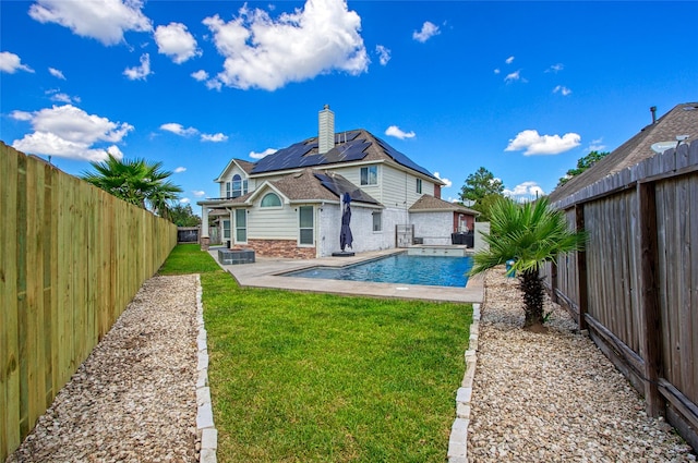 back of property with a yard, a fenced in pool, and a patio