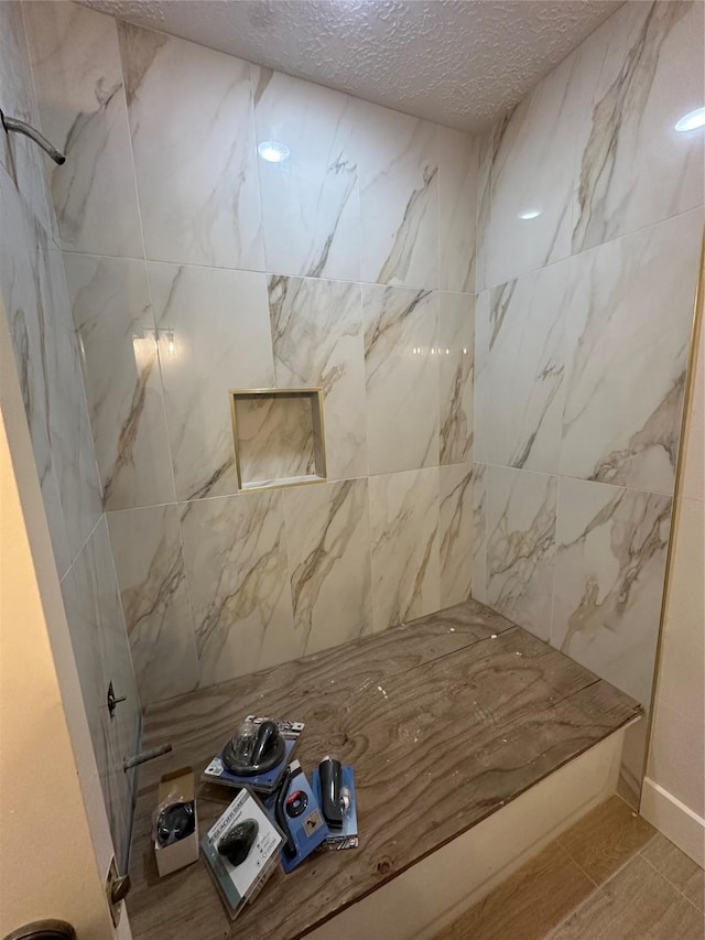 bathroom with a shower and a textured ceiling