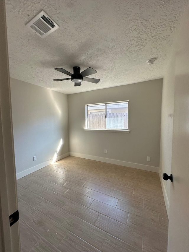 spare room featuring ceiling fan and a textured ceiling