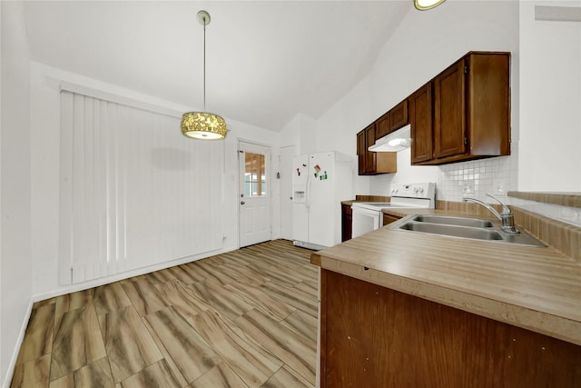 kitchen with backsplash, white appliances, vaulted ceiling, sink, and hanging light fixtures