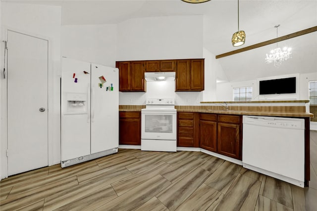 kitchen with sink, high vaulted ceiling, a chandelier, pendant lighting, and white appliances