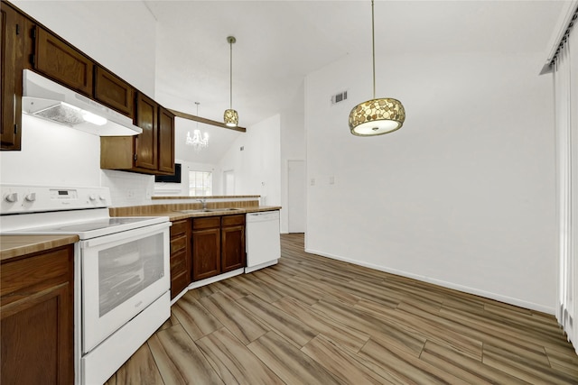 kitchen with sink, an inviting chandelier, tasteful backsplash, decorative light fixtures, and white appliances