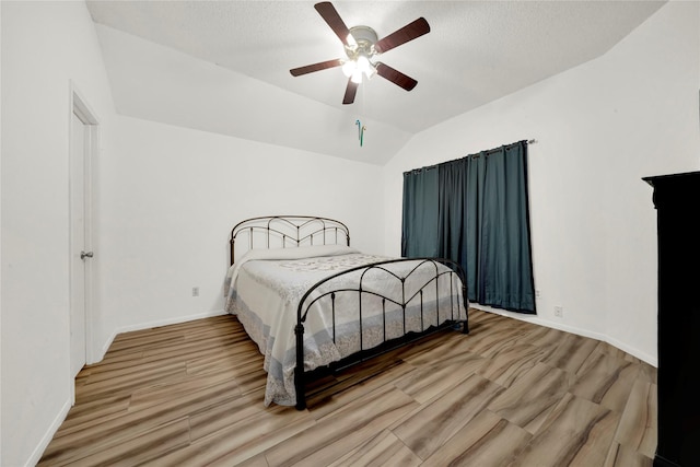 bedroom with hardwood / wood-style flooring, ceiling fan, and lofted ceiling