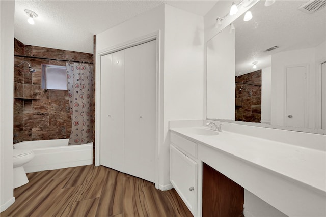 full bathroom featuring hardwood / wood-style floors, a textured ceiling, toilet, shower / bath combo with shower curtain, and vanity