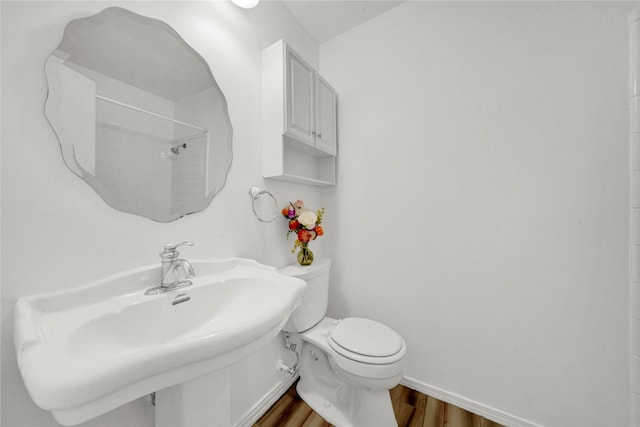 bathroom with a shower, hardwood / wood-style floors, toilet, and sink