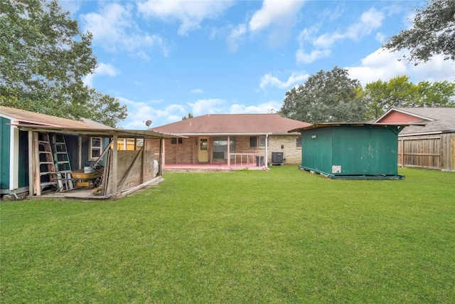 rear view of house with a lawn, a patio area, a shed, and cooling unit