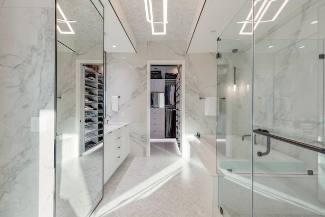 bathroom with vanity, a shower with shower door, and tile walls