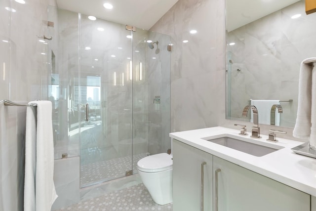 bathroom featuring vanity, toilet, walk in shower, and tile walls