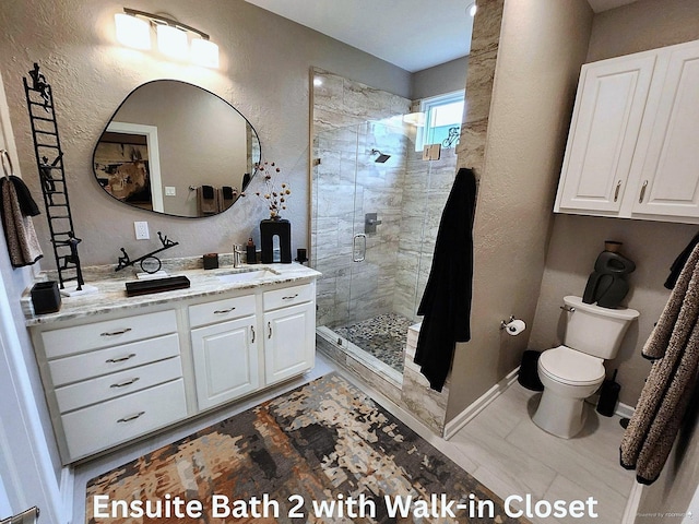 bathroom featuring tile patterned flooring, toilet, a shower with door, and vanity