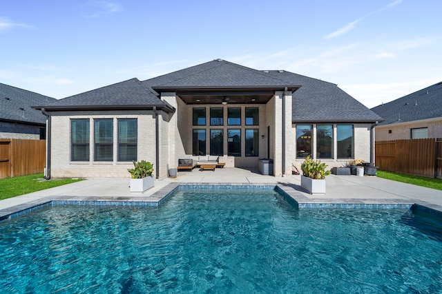 rear view of property featuring a fenced in pool, ceiling fan, and a patio