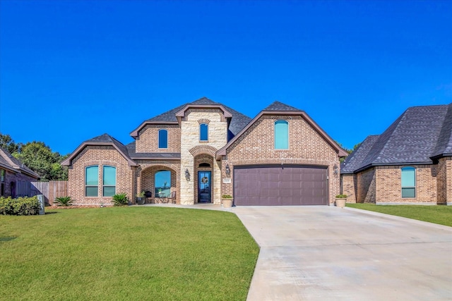 french country style house with a garage and a front lawn