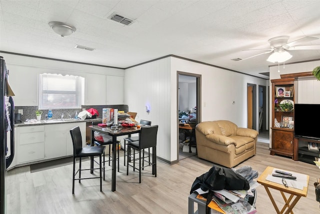 interior space featuring ceiling fan, sink, crown molding, and light hardwood / wood-style flooring