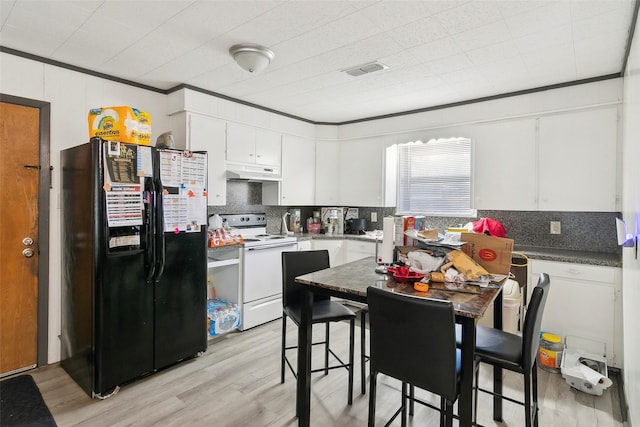 kitchen featuring black fridge, white cabinets, white electric range oven, and light wood-type flooring