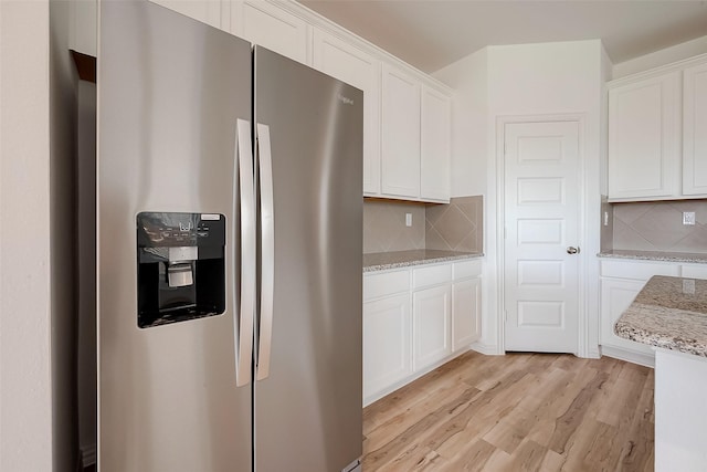 kitchen with decorative backsplash, white cabinets, stainless steel refrigerator with ice dispenser, and light wood-type flooring