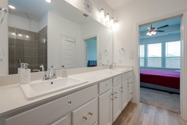 bathroom with ceiling fan, vanity, wood-type flooring, and walk in shower