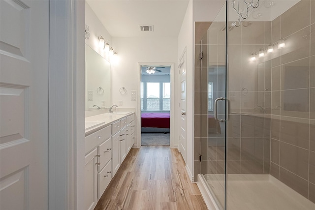 bathroom featuring ceiling fan, vanity, wood-type flooring, and walk in shower