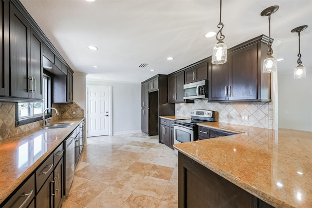 kitchen featuring sink, light stone counters, backsplash, pendant lighting, and appliances with stainless steel finishes