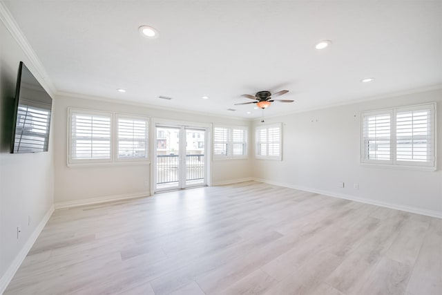 empty room featuring a wealth of natural light, light wood-type flooring, ceiling fan, and crown molding