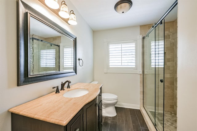 bathroom featuring toilet, an enclosed shower, and vanity