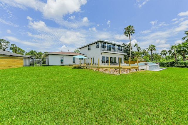 rear view of property featuring a patio area, a balcony, and a yard