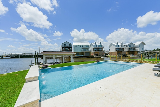 view of pool with pool water feature, a water view, and a patio