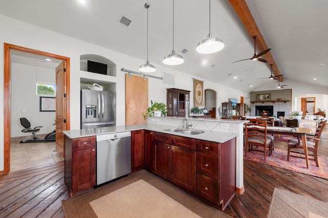 kitchen featuring stainless steel appliances, ceiling fan, sink, lofted ceiling with beams, and hanging light fixtures