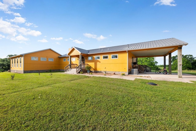 exterior space featuring a front lawn, a carport, and cooling unit