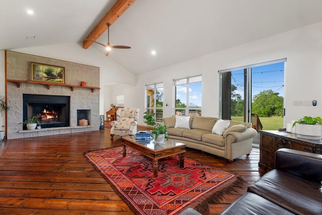 living room with ceiling fan, lofted ceiling with beams, a stone fireplace, and dark hardwood / wood-style floors