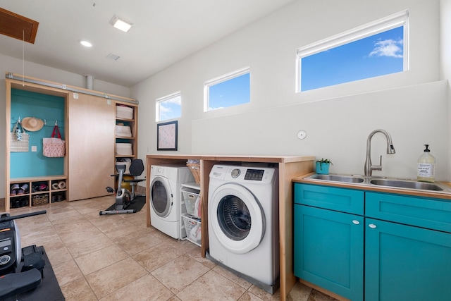 clothes washing area featuring light tile patterned flooring, cabinets, separate washer and dryer, and sink