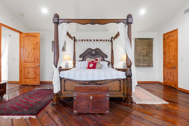 bedroom with dark hardwood / wood-style floors and lofted ceiling