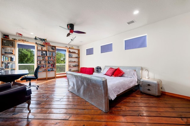 bedroom with ceiling fan, dark hardwood / wood-style flooring, and a textured ceiling