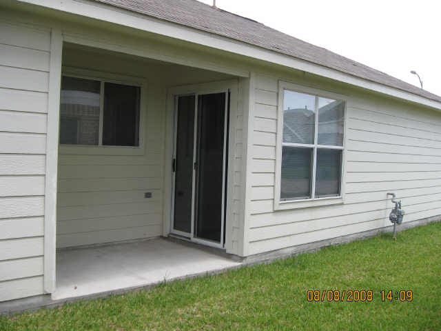 view of exterior entry with a patio area and a lawn