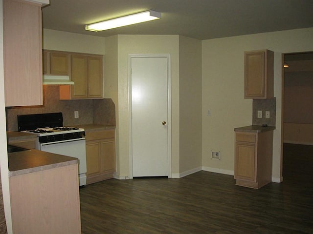 kitchen with light brown cabinetry, dark hardwood / wood-style floors, and white gas stove