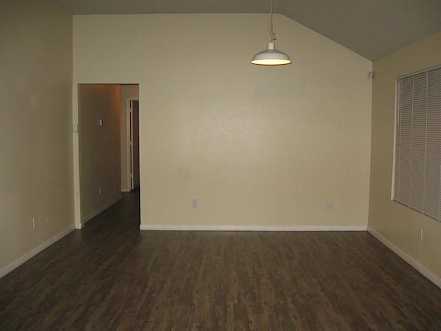 empty room featuring dark wood-type flooring and lofted ceiling