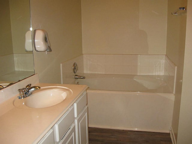 bathroom with hardwood / wood-style flooring, a bathtub, and vanity