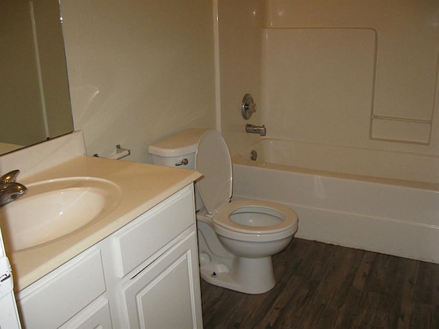 full bathroom with vanity, hardwood / wood-style floors,  shower combination, and toilet