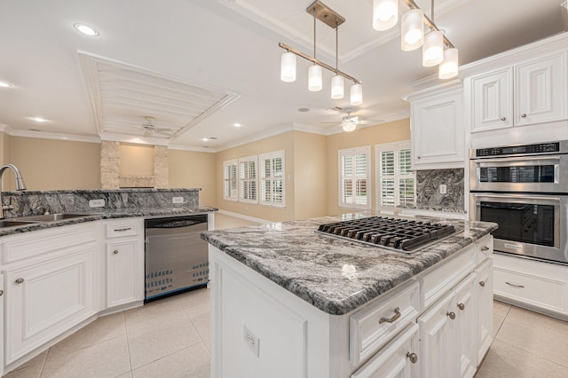 kitchen featuring ceiling fan, hanging light fixtures, a kitchen island, and stainless steel appliances