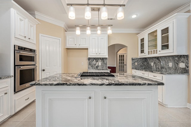 kitchen with decorative backsplash, stainless steel appliances, decorative light fixtures, white cabinets, and a kitchen island