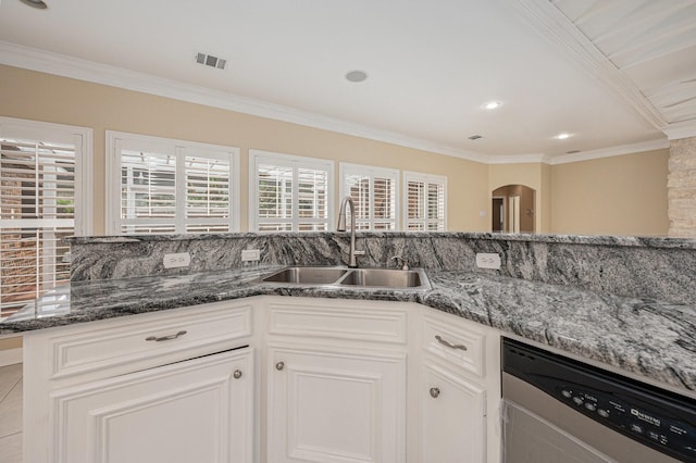 kitchen with white cabinets, ornamental molding, sink, dark stone countertops, and dishwasher