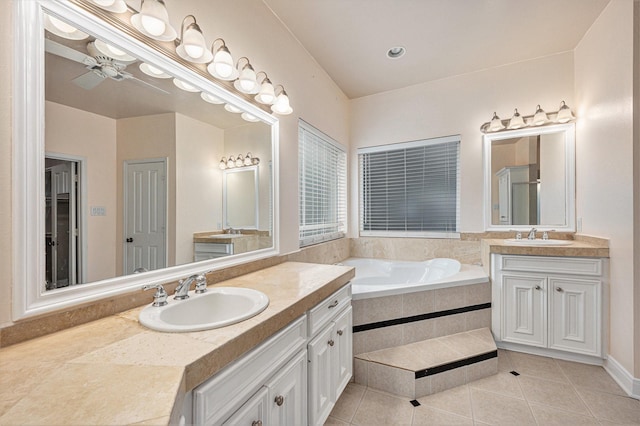 bathroom with tile patterned flooring, vanity, a relaxing tiled tub, and ceiling fan