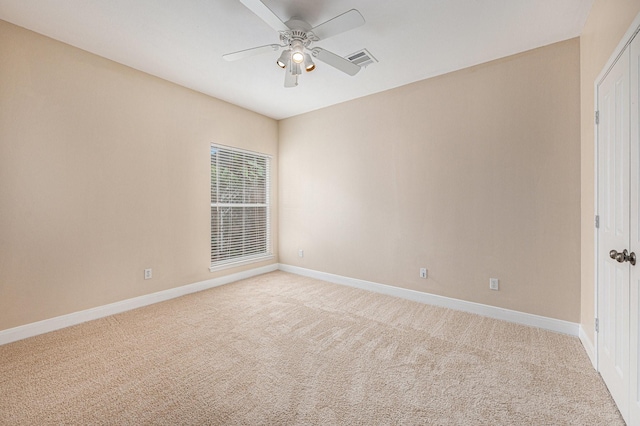 spare room featuring light colored carpet and ceiling fan