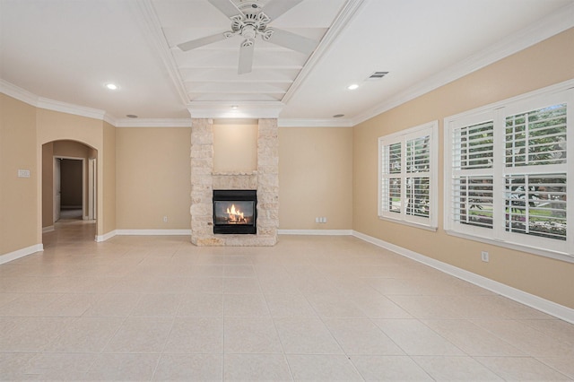 unfurnished living room featuring a stone fireplace, ceiling fan, light tile patterned floors, and ornamental molding