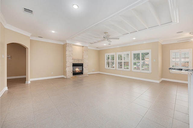 unfurnished living room featuring ceiling fan, light tile patterned flooring, crown molding, and a fireplace