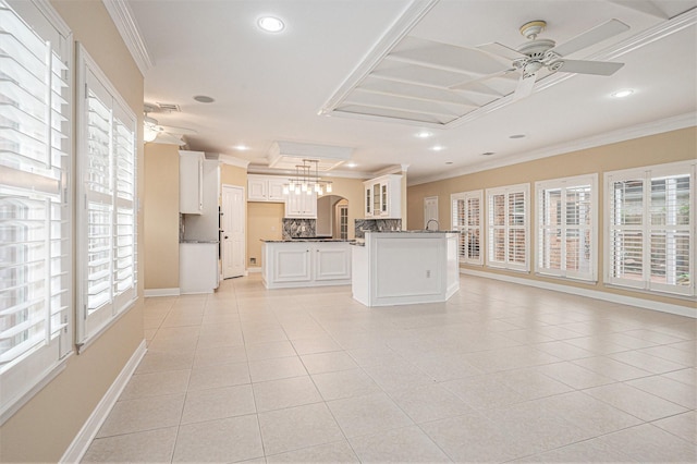 interior space with pendant lighting, light tile patterned flooring, ornamental molding, and a wealth of natural light