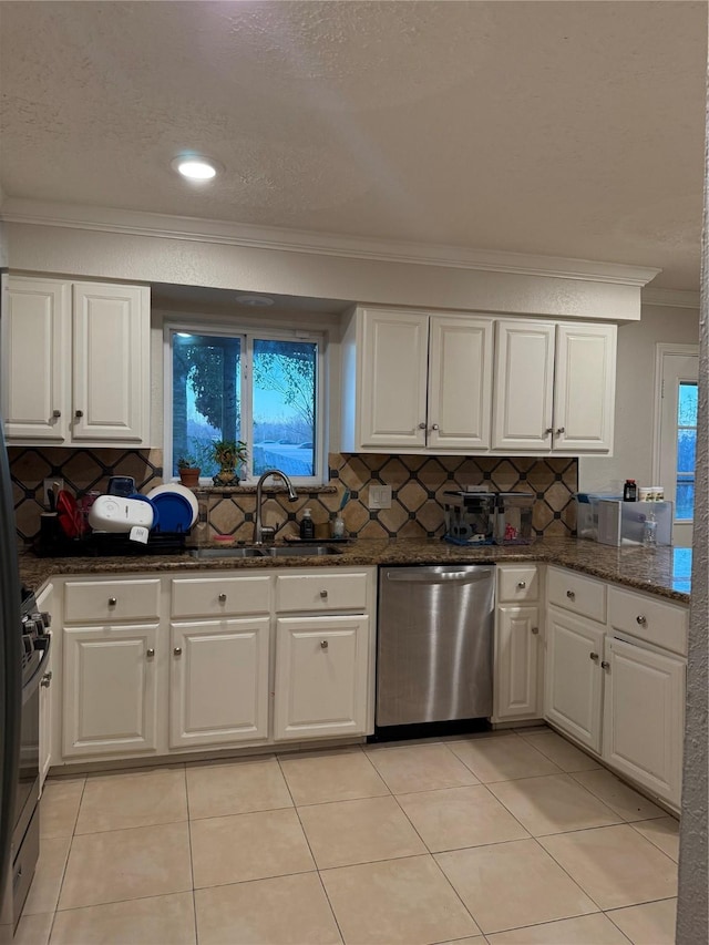 kitchen featuring backsplash, stainless steel appliances, sink, white cabinets, and light tile patterned flooring